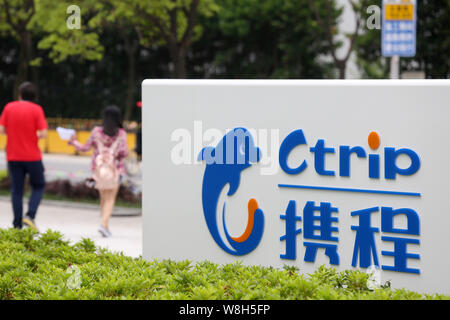 --FILE--pedoni a piedi passato un cartello di Ctrip presso la sede cinese di agenzia di viaggi online Ctrip in Cina a Shanghai, 14 maggio 2015. Ctrip Foto Stock