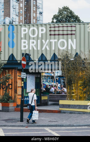 London, Regno Unito - 16 Luglio 2019: l'uomo a piedi nella parte anteriore del Pop Brixton, luogo dell'evento e la casa di una comunità di rivenditori indipendenti, ristoranti, street Foto Stock