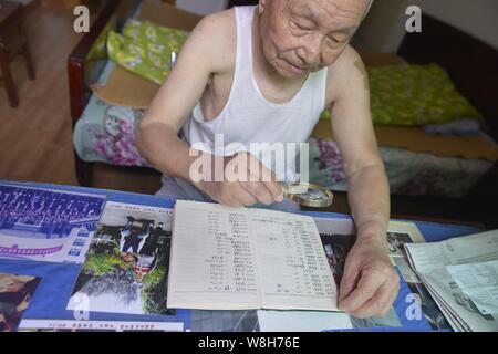 Il 97-anno-vecchio magazzino cinese investor Shi Kunsen guarda attentamente le info di negoziazione di azioni ha raccolto a casa nella città di Hangzhou, a est della Cina di Zhejia Foto Stock