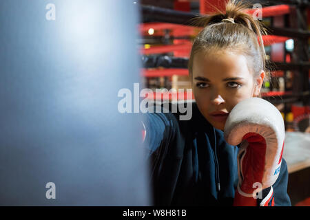 CHELYABINSK, Russia - 8 Giugno 2019: una giovane donna è la pratica di punzoni su un sacco da boxe. Ragazza boxe. Foto Stock