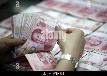 --FILE--un addetto cinese conta (RMB) renminbi yuan banconote presso una filiale della ICBC (industriale e banca commerciale della Cina) in città Huaibei, Oriente Cina Foto Stock