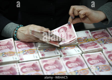 --FILE--un addetto cinese conta (RMB) renminbi yuan banconote presso una filiale della ICBC (industriale e banca commerciale della Cina) in città Huaibei, Oriente Cina Foto Stock