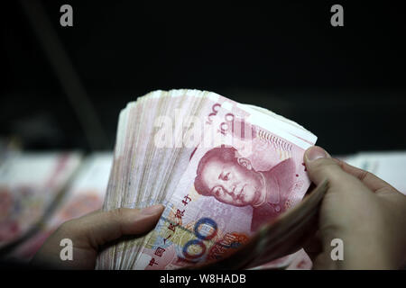 --FILE--un addetto cinese conta (RMB) renminbi yuan banconote presso una filiale della ICBC (industriale e banca commerciale della Cina) in città Huaibei, Oriente Cina Foto Stock