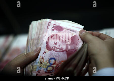 --FILE--un addetto cinese conta (RMB) renminbi yuan banconote presso una filiale della ICBC (industriale e banca commerciale della Cina) in città Huaibei, Oriente Cina Foto Stock