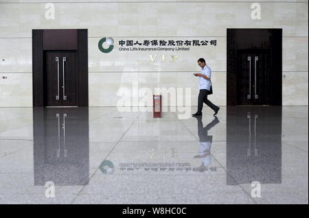 --FILE--un passeggero passeggiate passato un VIP center di China Life Insurance Company Limited a Zhengzhou Stazione ferroviaria nella Città di Zhengzhou, porcellane centrale Foto Stock