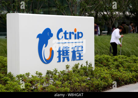 --FILE--un pulitore cinese lavora accanto a un cartello di Ctrip presso la sede cinese di agenzia di viaggi online Ctrip in Cina a Shanghai, 14 maggio 2015 Foto Stock