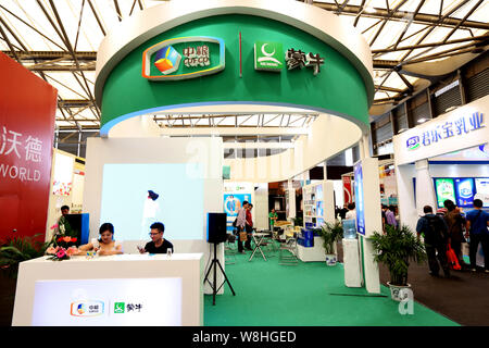 --FILE -- la gente visita lo stand della COFCO (China National i cereali, gli oli e i prodotti alimentari Corporation) e Mengniu durante una mostra a Shanghai in Cina, Foto Stock