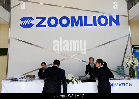 --FILE--dipendenti cinesi servire i visitatori allo stand di Zoomlion durante il 2014 Fiera Internazionale per la costruzione di macchinari, costruzione di materi Foto Stock