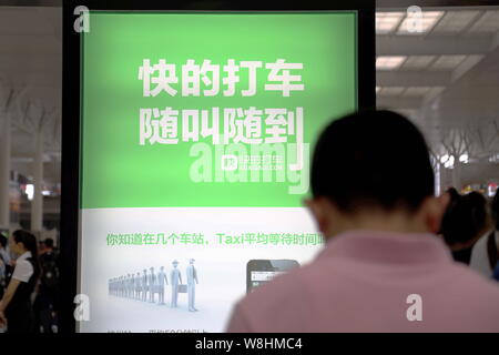 --FILE -- la gente visita lo stand della prenotazione taxi app Kuaidi Dache di Alibaba durante una mostra a Shanghai in Cina, 24 luglio 2014. Gruppo Kuaidi, uno Foto Stock