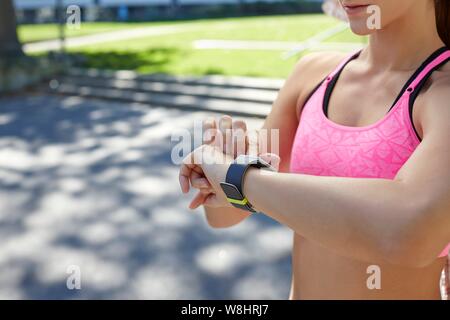 Donna che indossa orologio sportivo controllando il tempo. Foto Stock