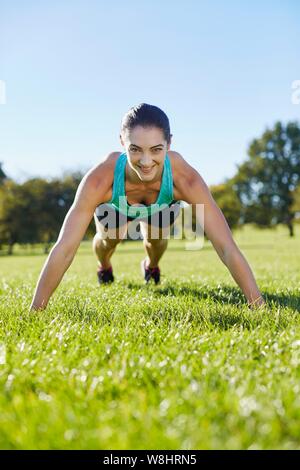 Giovane donna facendo push-up. Foto Stock