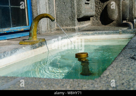 Acqua fresca potabile aspersione fuori la vecchia fontana con acqua in ottone tocca a Zurigo - formato verticale, primo piano Foto Stock