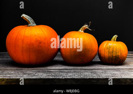 Tre autunno zucche di Halloween su sfondo di legno Foto Stock