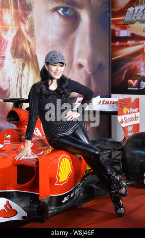 Attrice canadese Christy Chung pone con una Ferrari Formula One race car durante una Premiere per il film 'rush' a Pechino, in Cina, il 10 dicembre 2015. Foto Stock