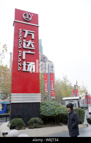 --FILE--A passeggiate a piedi passato un cartello di Wanda Plaza di Wanda Group in Cina a Shanghai, 3 dicembre 2014. Proprietà cinese e intrattenimento gi Foto Stock