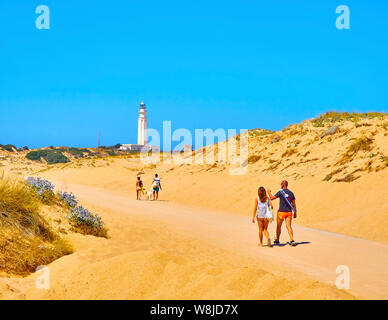 I turisti a piedi in un ampia spiaggia di dune di sabbia fine del Cabo de Trafalgar Cape parco naturale. Los Caños de Meca, Spagna. Foto Stock