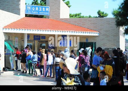 --FILE--turisti in coda fino a fronte di un wc pubblico in corrispondenza di un punto panoramico nella città di Qingdao, Cina orientale della provincia di Shandong, 3 ottobre 2014. Cina believ Foto Stock