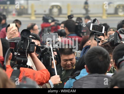 Generale Cinese Mao Xinyu, anteriore, il nipote di Mao Zedong, è circondato dai giornalisti come egli arriva presso la Grande Sala del Popolo di frequentare l'o Foto Stock