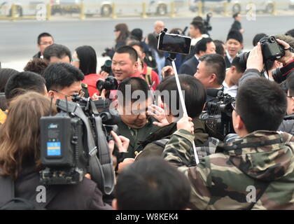 Generale Cinese Mao Xinyu, anteriore, il nipote di Mao Zedong, è circondato dai giornalisti come egli arriva presso la Grande Sala del Popolo di frequentare l'o Foto Stock