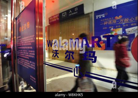 --FILE--pedoni a piedi passato un supermercato Walmart in Luoyang city, centrale cinese della provincia di Henan, 18 dicembre 2013. Wal-Mart ha firmato di recente un s Foto Stock