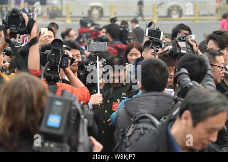 Generale Cinese Mao Xinyu, anteriore, il nipote di Mao Zedong, è circondato dai giornalisti come egli arriva presso la Grande Sala del Popolo di frequentare l'o Foto Stock