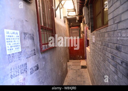 Annunci di alloggiamento per gli acquisti sono incollati sulle pareti delle case in un vicolo a Wenchang Hutong in Xicheng District, Pechino, Cina, 7 marzo 2016. Un cantare Foto Stock