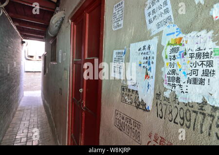 Annunci di alloggiamento per gli acquisti sono incollati sul muro di una casa in un vicolo a Wenchang Hutong in Xicheng District, Pechino, Cina, 7 marzo 2016. Un cantare Foto Stock