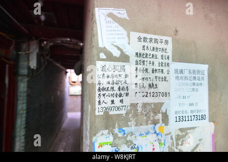 Annunci di alloggiamento per gli acquisti sono incollati sul muro di una casa in un vicolo a Wenchang Hutong in Xicheng District, Pechino, Cina, 7 marzo 2016. Un cantare Foto Stock