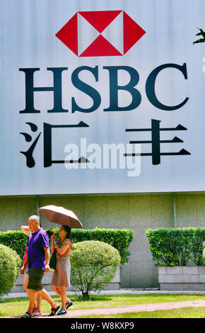 --FILE--pedoni a piedi passato un cartellone di HSBC nella città di Guangzhou, Cina del sud della provincia di Guangdong, 24 agosto 2015. La prima immagine chiara della HSB Foto Stock