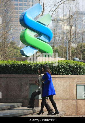 --FILE--pedoni a piedi passato la segnaletica di Standard Chartered presso una filiale della banca nel Quartiere Finanziario di Lujiazui di Pudong, Shanghai, Cina Foto Stock