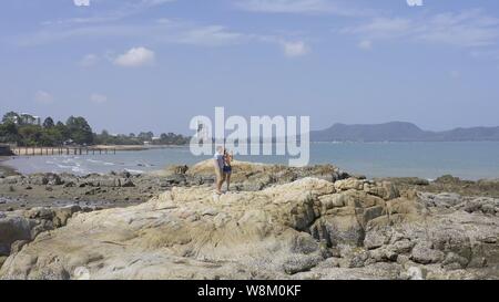 Giovane a piedi vicino al mare. Giovane a camminare su di una scogliera sul mare. giovane prendendo un selfie Foto Stock