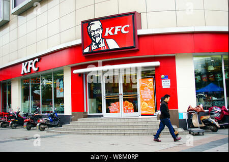 --FILE--pedoni a piedi passato a un fast food ristorante di KFC in Yichang city, centrale cinese della provincia di Hubei, 13 gennaio 2016. Tre technology compani Foto Stock