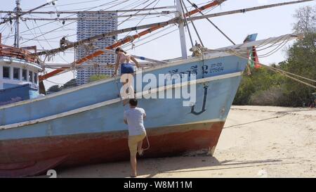 Pattaya, Tailandia - 18 Maggio 2019: vacanze romantiche e viaggi di lusso. Giovani amanti alzarsi salire in barca. Barca a vela in mare Foto Stock