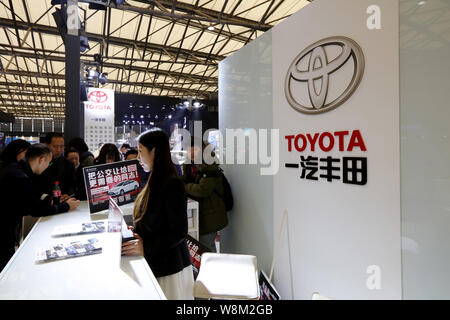 --FILE--dipendenti cinesi servire i visitatori allo stand della Toyota durante un salone automobilistico in Cina a Shanghai, 11 dicembre 2015. Toyota Motor C Foto Stock