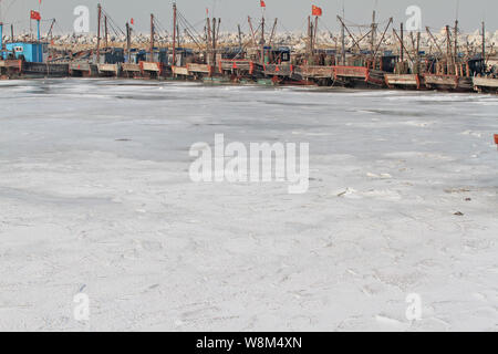 Barche da pesca sono intrappolati nel mare di ghiaccio in un porto nella città di Penglai, est della Cina di provincia di Shandong, 26 gennaio 2016. Barche da pesca sono stati intrappolati in mare i Foto Stock