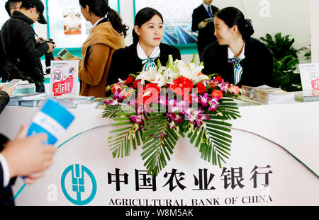 --FILE--dipendenti cinesi parlare presso lo stand della Banca agricola di Cina (ABC) durante la xi Beijing International Finance Expo (Finexpo 2015) in B Foto Stock