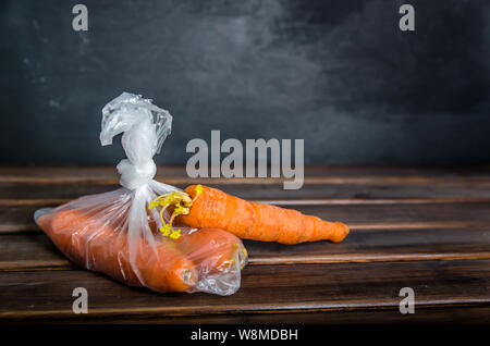 Concetto plasic libera le carote in un sacchetto di plastica su uno sfondo marrone con spazio di copia Foto Stock