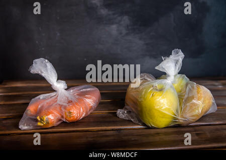 Concetto di libero in plastica di frutta e verdura in sacchetti di plastica su uno sfondo marrone con spazio di copia Foto Stock