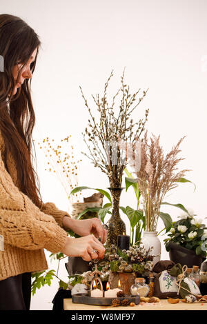 Natura morta con fiori secchi e i rami di salici. Il Decor. decorazioni, candele, rami secchi di Willow e una ragazza sullo sfondo. Il concetto di un tr Foto Stock