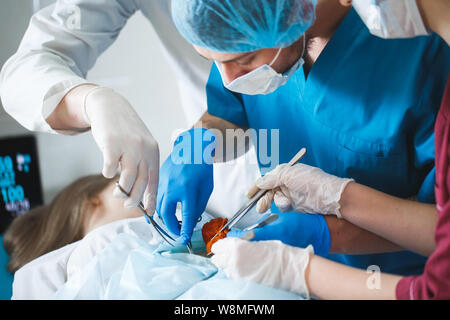 Vicino il dettaglio di un intervento chirurgico. Gruppo di chirurghi al lavoro che operano in sala operatoria. Foto Stock