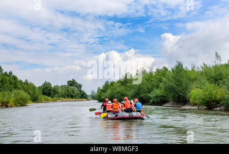 Rafting sul fiume con le famiglie e i bambini sul fiume Iller nelle Alpi dell'Algovia Foto Stock