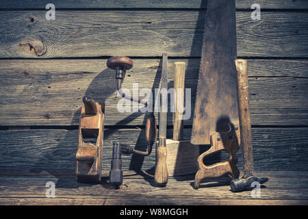 Vista dettagliata del martello, sega e scalpello in workbench rustico Foto Stock