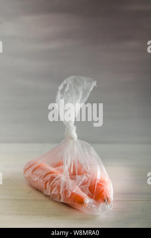 Concetto plasic libera le carote in un sacchetto di plastica su uno sfondo bianco con spazio di copia Foto Stock