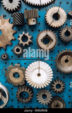Varie di metallo arrugginito ruote dentate visualizzato a sfondo blu Foto Stock