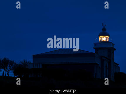 Lanterna del faro di San Vicente de la Barquera che splende al buio. Cantabria, Spagna Foto Stock