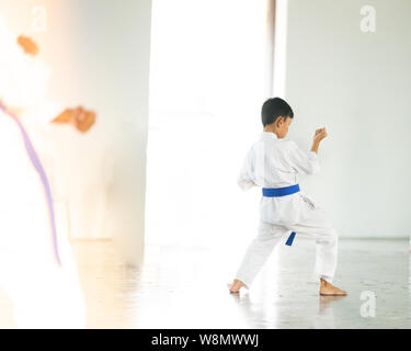 Giovane ragazzo in cintura blu di karate di formazione. Foto Stock