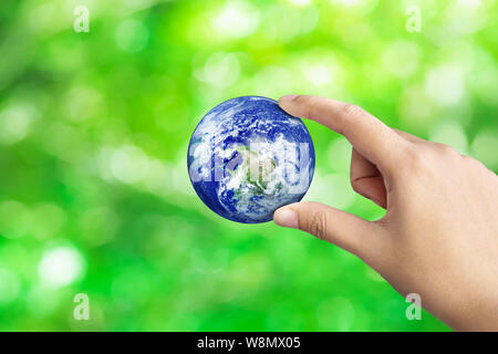 Tenendo la mano sulla terra verde natura Bokeh blur sullo sfondo, salvare il mondo concetto,elementi di questa immagine fornita dalla NASA Foto Stock