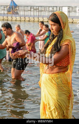 Un giovane indiano donna Indù che indossa un sari esegue una prima mattina rituale del bagno nel fiume Gange a Varanasi, Uttar Pradesh, India, Asia del Sud Foto Stock