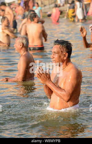 Un uomo indiano offre preghiere agli dèi nel corso di un inizio di mattina rituale del bagno nel fiume Gange a Varanasi, Uttar Pradesh, India, Asia del Sud. Foto Stock