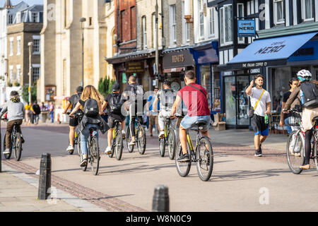 Cambridge, UK, 1 agosto 2019. Un gruppo di ciclisti sulla strada di Cambridge per una intensa giornata di sole di fronte il Kings College Foto Stock